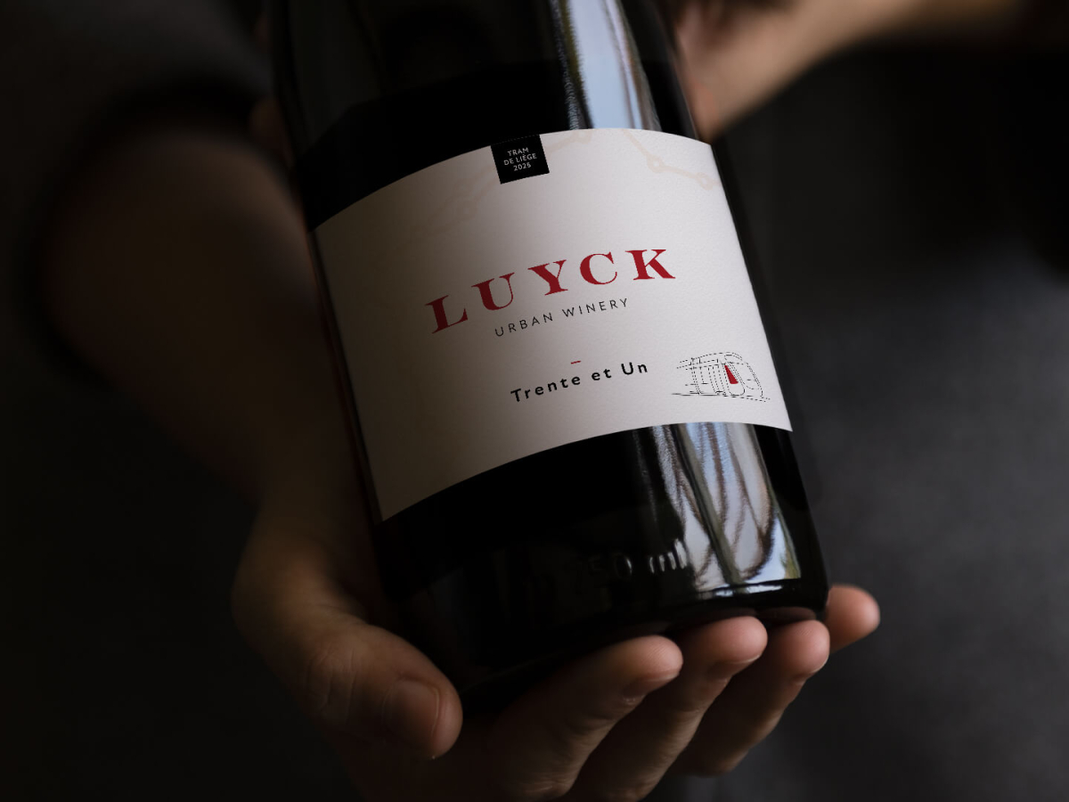 Main tenant une bouteille de vin avec la nouvelle étiquette personnalisée Luyck
