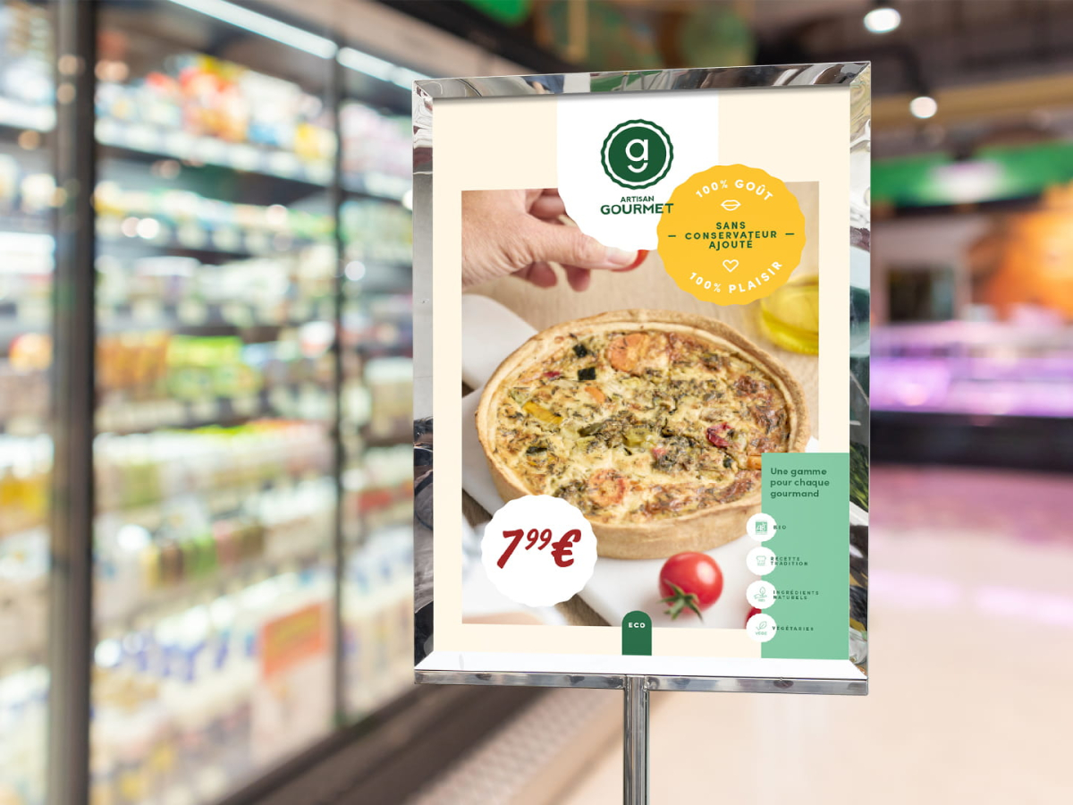 Affiche publicitaire Artisan Gourmet installée dans le rayon frais d'un supermarché